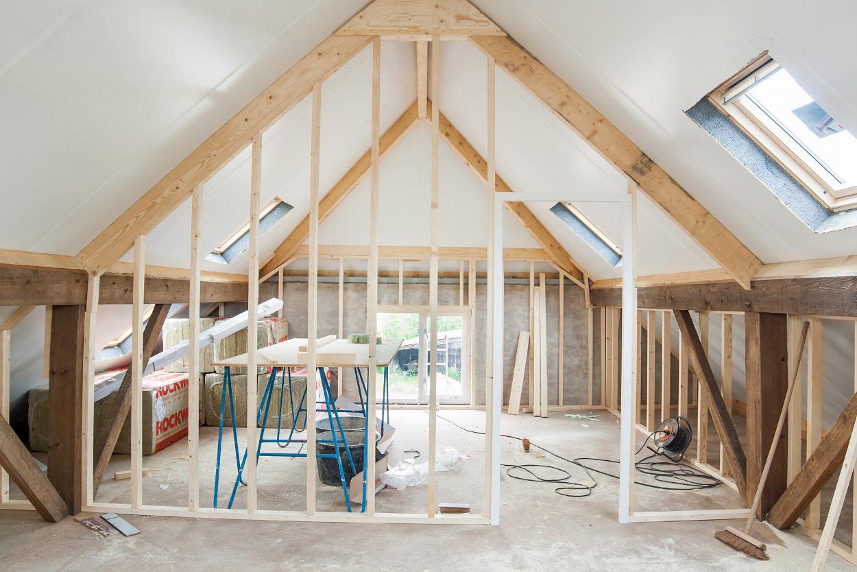 Loft conversion in progress with timber stud walls and roof windows